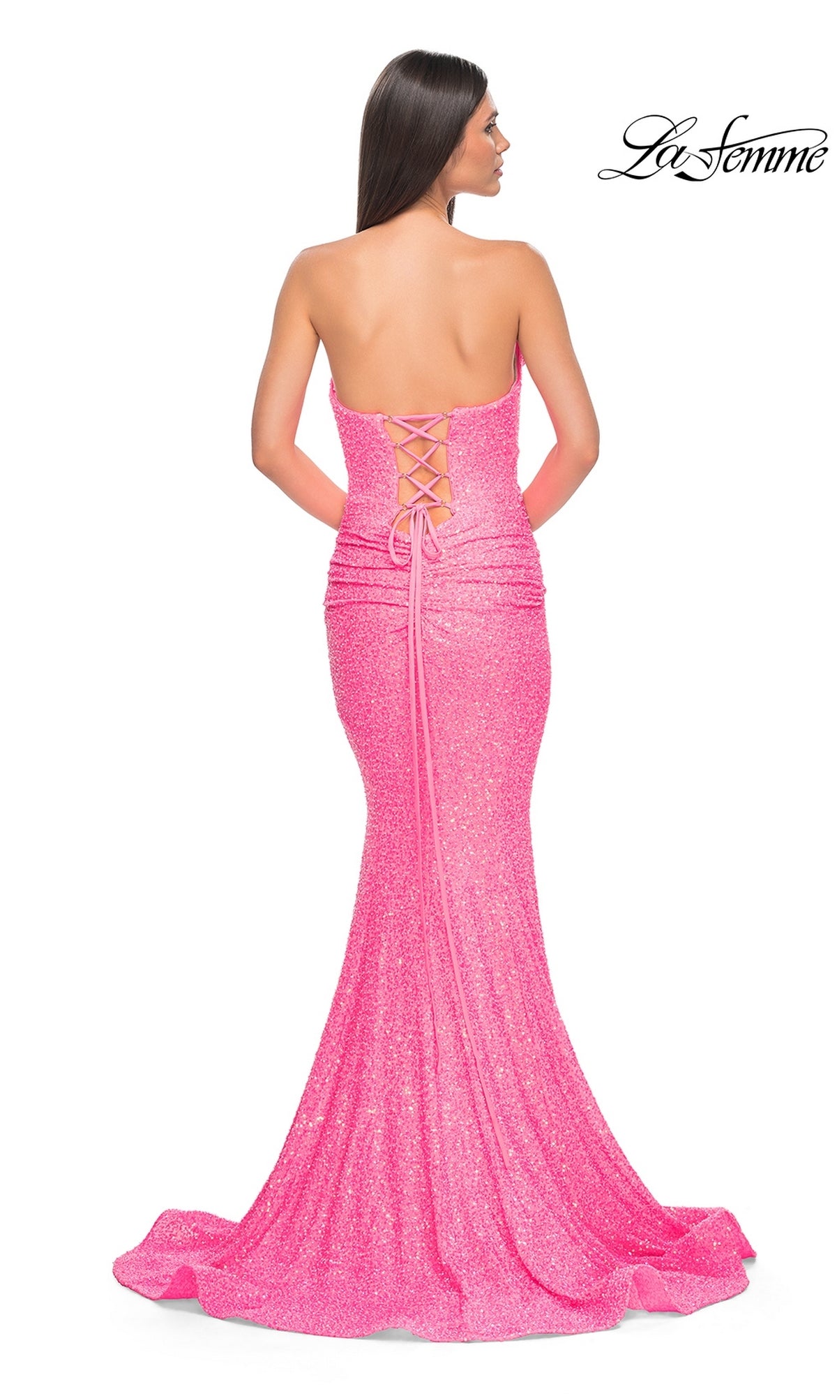 A woman in a strapless, floor-length pink La Femme Strapless Long Sequin Prom Dress 39092 with a lace-up back stands facing away. The La Femme logo appears in the top right corner.